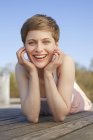 Portrait of laughing woman lying on jetty — Stock Photo