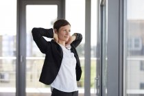 Businesswoman in office looking out of window — Stock Photo