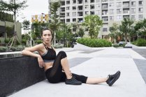 Fit woman relaxing after exercising in urban environment — Stock Photo