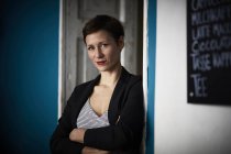 Porträt einer Geschäftsfrau, die sich in die Tür lehnt — Stockfoto