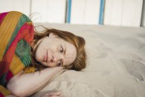 Mulher ruiva descansando na areia na praia — Fotografia de Stock