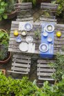Table de jardin posée avec des assiettes et des bols colorés — Photo de stock