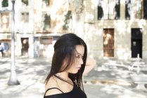 Задумчивая красивая азиатка на улице в очках — стоковое фото