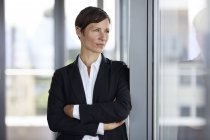 Geschäftsfrau im Büro schaut aus dem Fenster — Stockfoto