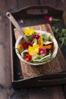 Bowl of mixed salad with herbs and edible flowers — Stock Photo