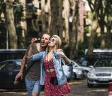 Casal soprando bolhas de sabão na cidade juntos — Fotografia de Stock