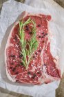 Bistecca cruda con rosmarino, sale e pepe — Foto stock
