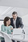 Бізнесмен і бізнесжінка, що має зустріч в офісі з ноутбуком — стокове фото