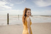 Retrato de una pelirroja, riendo felizmente en la playa - foto de stock