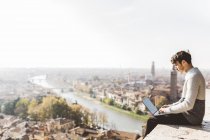 Italy, Verona, tourist using laptop at observation point — Stock Photo