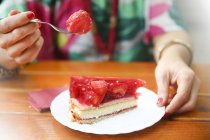 Primo piano della donna che mangia torta di fragole nel caffè di strada — Foto stock