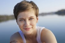 Porträt einer lächelnden Frau vor dem See — Stockfoto