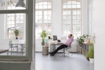 Man working at desk in a loft office — Stock Photo