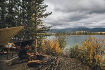 Canada, British Columbia, man making camp fire at Boya Lake — стокове фото