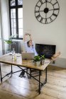 Femme détendue assise au bureau à la maison avec les pieds levés — Photo de stock