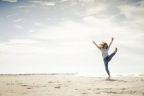 Happy woman having fun at the beach, dancing in the sand — Stock Photo