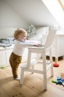 Little boy at home playing with laptop — Stock Photo