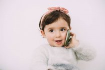 Retrato de menina sorrindo olhando para o telefone celular — Fotografia de Stock