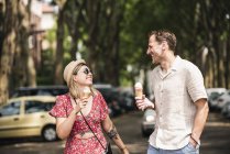 Casal feliz com cones de sorvete andando na cidade — Fotografia de Stock