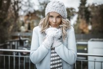 Portrait de femme souriante portant un chapeau, des gants et une écharpe en laine — Photo de stock