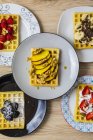 Plates of waffles with various toppings — Stock Photo