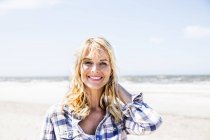 Porträt einer lächelnden Frau am Strand — Stockfoto