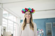 Portrait of smiling woman with colourful Christmas bauble wreath on her head — Stock Photo