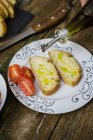 Preparing bruschetta, olive oil and tomato on plate — Stock Photo