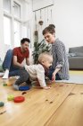 Family sitting on ground, playinhg with their little daughter — Stock Photo