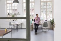 Man talking on cell phone in a loft office — Stock Photo