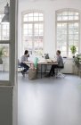 Colleagues working at desk in a loft office — Stock Photo