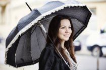 Retrato de mujer joven de moda con paraguas vintage negro - foto de stock