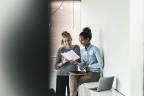 Giovani donne che lavorano insieme in ufficio, leggendo documenti — Foto stock