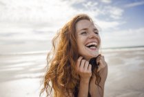 Ritratto di una donna dai capelli rossi, che ride felice sulla spiaggia — Foto stock