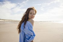 Mulher na praia, olhando por cima do ombro — Fotografia de Stock
