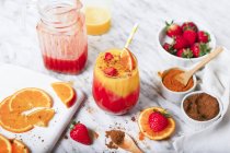 Frullato di fragole e arancia con curcuma e cannella su marmo — Foto stock