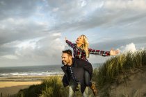 Joyeux couple ludique dans les dunes — Photo de stock