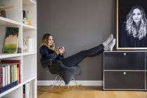Contenu jeune femme relaxant avec boisson chaude à la maison — Photo de stock