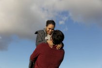 Счастливая молодая пара обнимается на открытом воздухе — стоковое фото
