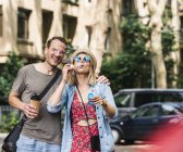 Casal feliz com café para ir soprar bolhas de sabão na cidade — Fotografia de Stock