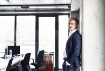 Portrait de l'homme d'affaires mature confiant debout dans le bureau — Photo de stock
