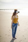 Mujer pelirroja usando gafas VR en la playa - foto de stock