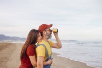 Couple with binoculars on the beach — Stock Photo