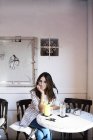 Portrait de jeune femme assise dans un café — Photo de stock