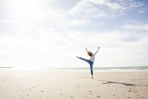 Happy woman having fun at the beach, jumping in the air — Stock Photo