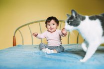 Sorpresa bambina con gatto sul letto — Foto stock