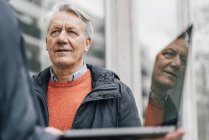 Senior sieht Mann mit Laptop im Freien an — Stockfoto
