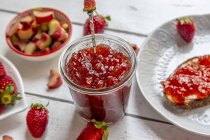 Bicchiere di marmellata di rabarbaro alla fragola sul tavolo della colazione — Foto stock