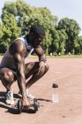 Young athlete doing weight training with dumbbells on sports field — Stock Photo
