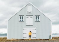 Iceland, woman with guitar standing at lonely house — Stock Photo